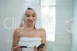 Woman holding make-up in bathroom