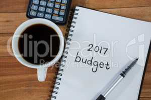 Close-up of coffee cup with diary and pen