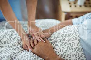 Nurse holding hands of senior woman