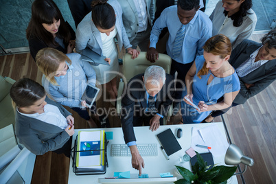 Businessman discussing with colleagues over computer