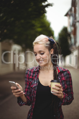 Woman using mobile phone while walking on street