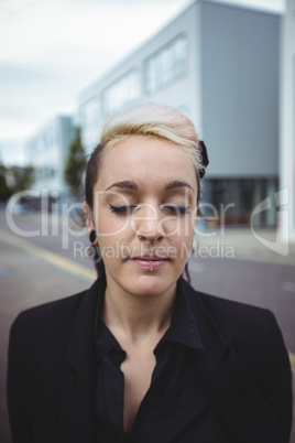 Businesswoman standing with eyes closed