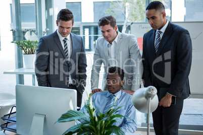 Businesspeople discussing at table over computer