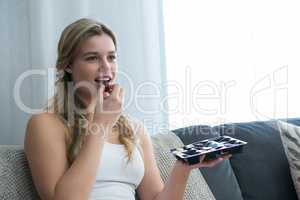 Woman eating chocolates in living room