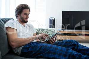 Man using digital tablet in living room