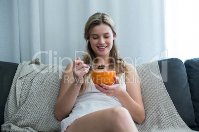 Woman having breakfast in living room