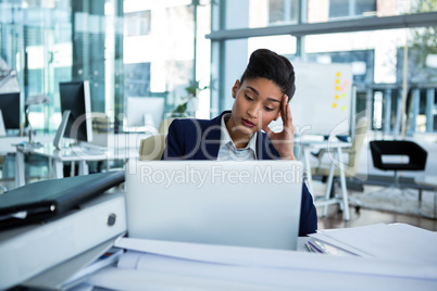 Stressed businesswoman sitting at her desk