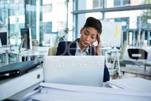 Stressed businesswoman sitting at her desk