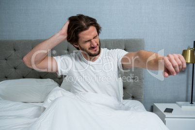 Man waking up in bed and stretching her arms