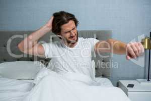 Man waking up in bed and stretching her arms