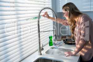 Woman looking through window blinds