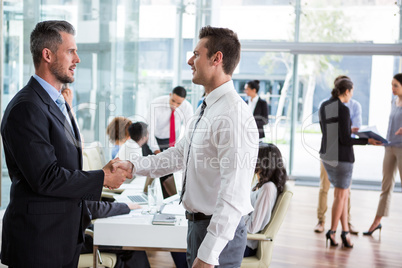 Businessmen shaking hands in office