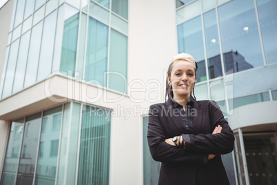 Portrait of smiling businesswoman standing with arms crossed
