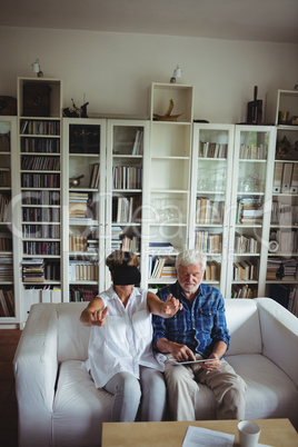 Senior couple using digital tablet and virtual reality headset