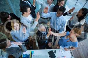 Businesspeople giving high five to each other