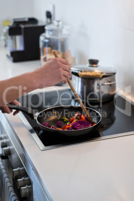 Hand of a man preparing food in kitchen