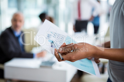 Businesswoman showing chart in office