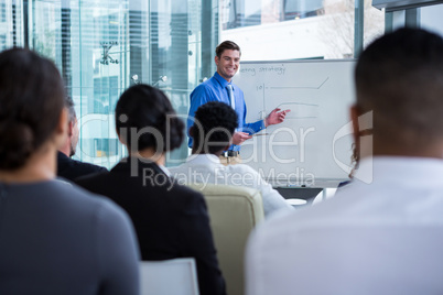 Businessman discussing on white board with coworkers