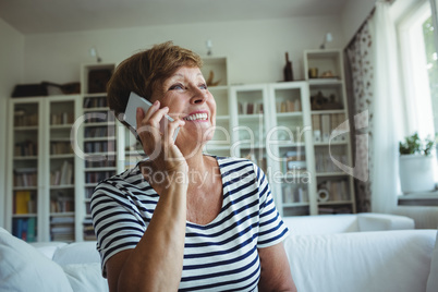 Senior woman talking on mobile phone in living room