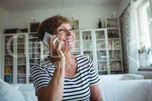 Senior woman talking on mobile phone in living room