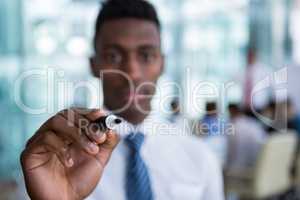 Businessman writing with marker on glass