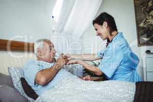 Nurse giving a glass of water to senior man