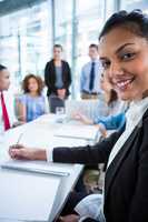 Businesswoman writing notes in office