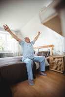 Senior man yawning on bed