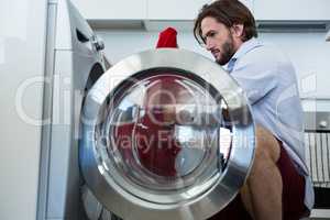 Man putting his clothes into washing machine