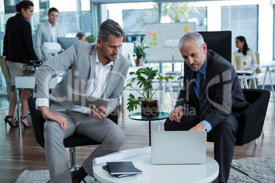 Businesspeople discussing over laptop