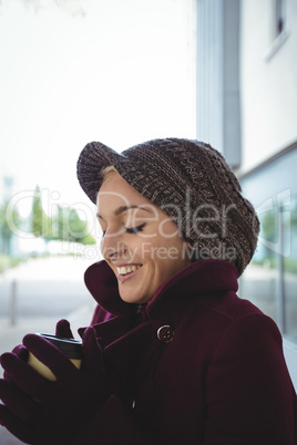 Woman smiling and holding a cup of coffee