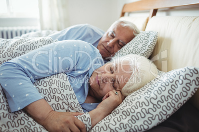 Senior couple sleeping on bed