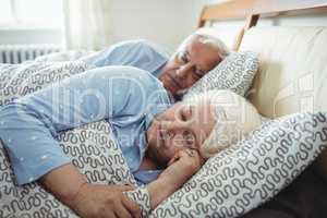 Senior couple sleeping on bed