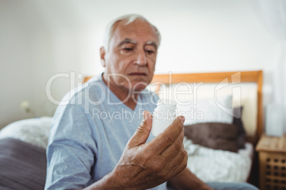 Senior man looking at pill bottle