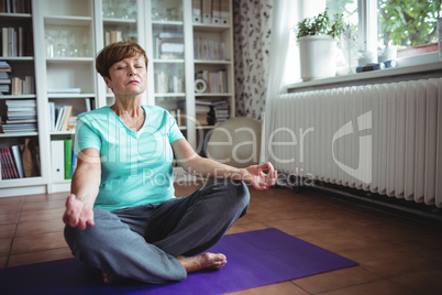 Senior woman meditating in lotus position