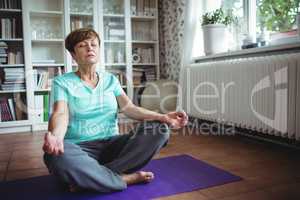 Senior woman meditating in lotus position