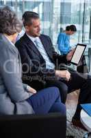 Businesspeople having discussion over digital tablet