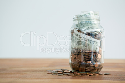 Close-up of coins and currency notes in jar