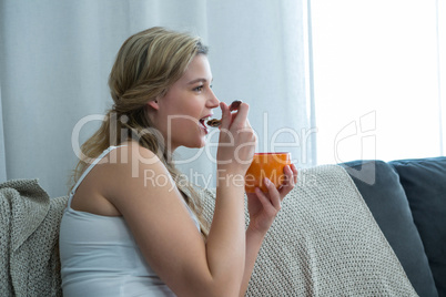 Woman having breakfast in living room