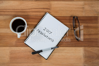 Close-up of coffee cup with diary and belongings