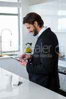 Businessman using digital tablet in kitchen