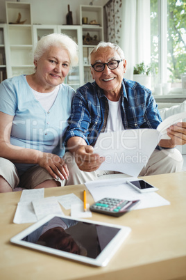 Senior couple smiling while checking the bills