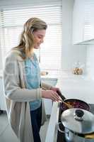 Woman cooking food in kitchen