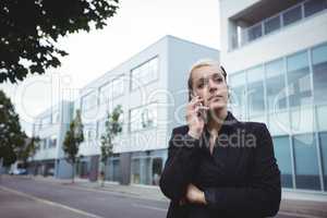 Thoughtful businesswoman standing with arms crossed
