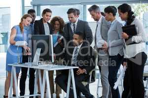 Group of businesspeople discussing over computer