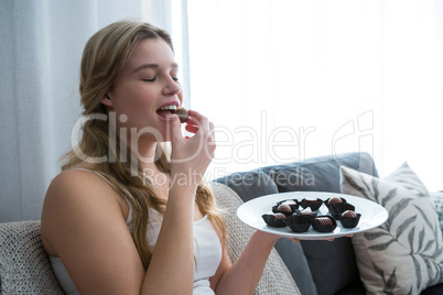 Woman eating chocolates in living room