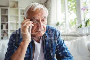 Tensed senior man talking on mobile phone