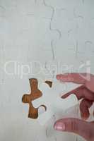 Woman placing missing piece in Jigsaw puzzle
