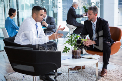 Businessmen having discussion over digital tablet