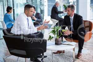 Businessmen having discussion over digital tablet